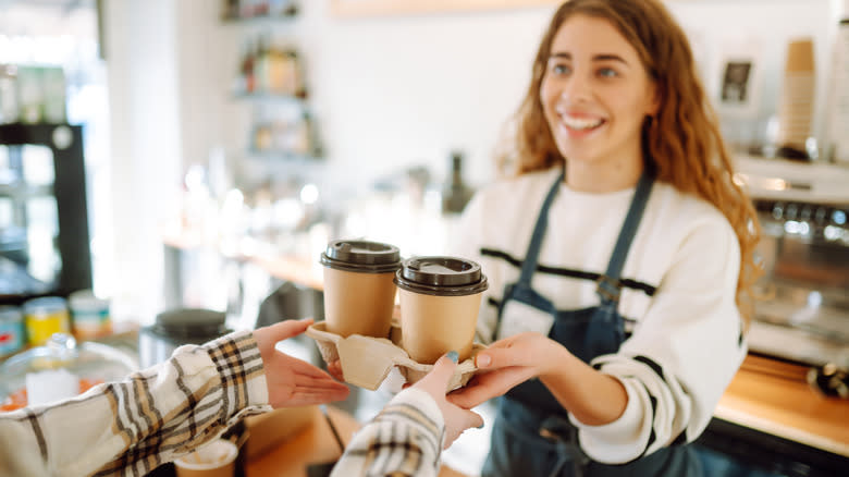 female barista handing coffee