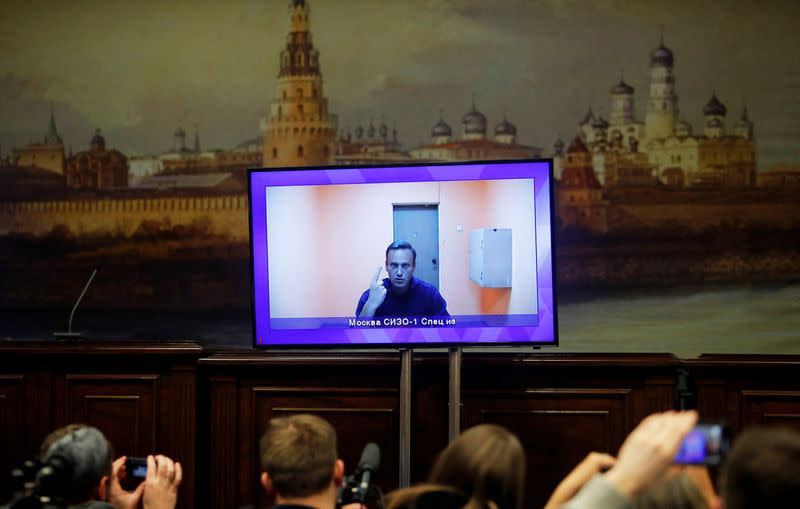 FILE PHOTO: Russian opposition leader Alexei Navalny is seen on a screen via a video link during a court hearing to consider an appeal on his arrest, outside Moscow