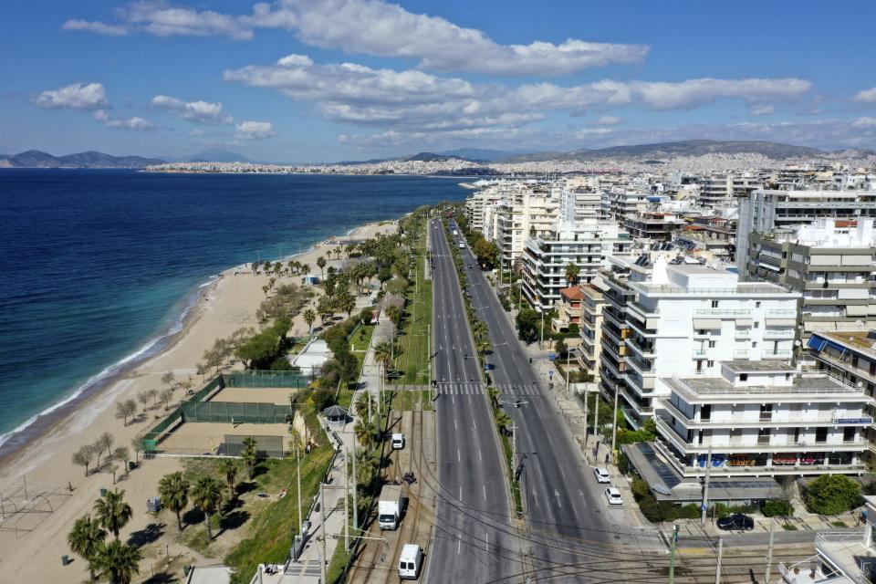 In this Thursday, April 2, 2020 photo, vehicles on Poseidonos avenue, with the beach of Paleo Faliro at left, in southern Athens during the lockdown. Deserted squares, padlocked parks, empty avenues where cars were once jammed bumper-to-bumper in heavy traffic. The Greek capital, like so many cities across the world, has seen its streets empty as part of a lockdown designed to stem the spread of the new coronavirus. (AP Photo/Thanassis Stavrakis)