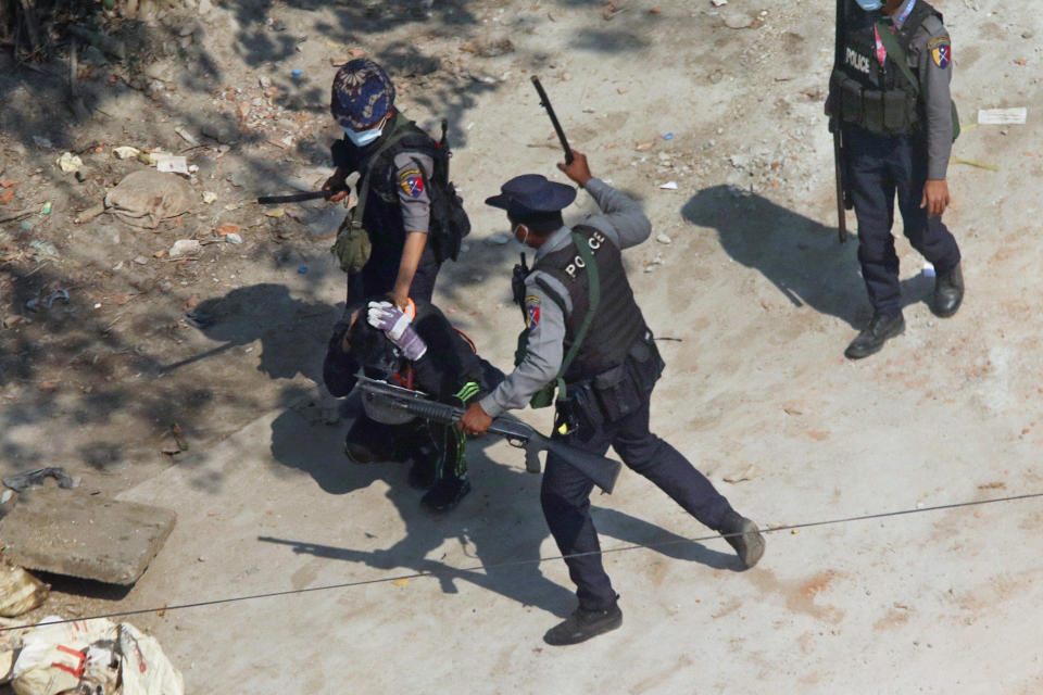 FILE - In this Saturday, March 6, 2021 file photo, police officers hold down a protester as they disperse demonstrators in Tharkata Township on the outskirts of Yangon, Myanmar. The United Nations says after a military takeover of the country, more than 850 people have been killed since Feb. 1 and more than 4,800 arbitrarily detained. (AP Photo, File)