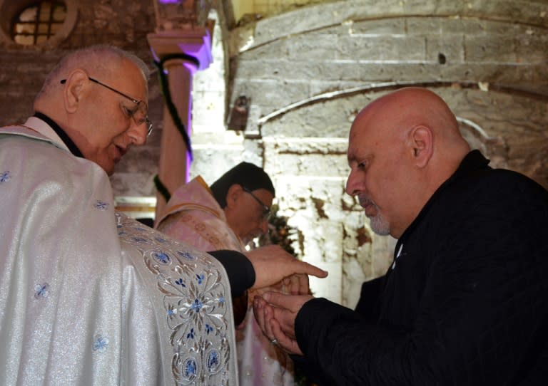 A man receives the Eucharist during a Christmas mass at Saint Paul's church in Iraq's second city Mosul on December 24, 2017