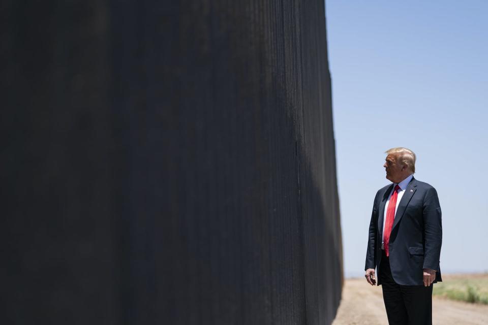 Trump stands next to the border wall in Arizona.