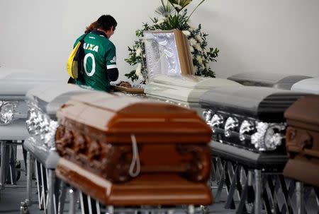 A relative wearing a jersey of Brazilian soccer team Chapecoense looks into the coffin of Nilson Folle Junior, one of the soccer team's managers and who died along with others in an accident of the plane that crashed into the Colombian jungle with the Brazilian soccer team onboard, in Medellin, Colombia December 1, 2016. REUTERS/Jadime Saldarriaga