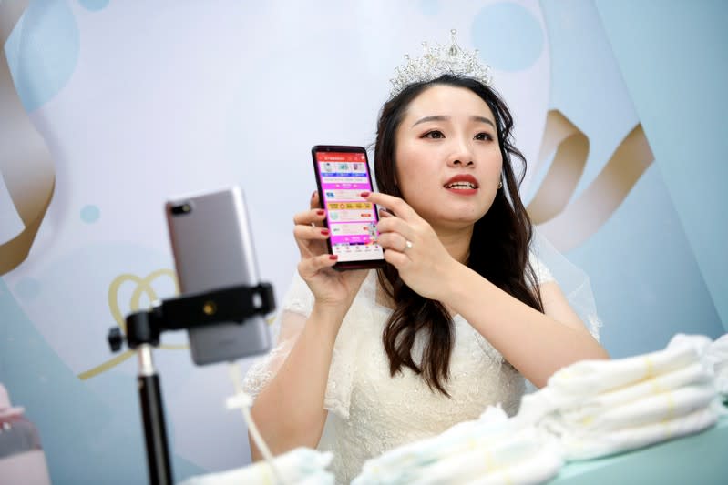 Live-streaming anchor wearing a wedding gown promotes baby diapers through a live streaming session on the eve of the 11.11 Singles' Day shopping festival, at a studio in Hangzhou