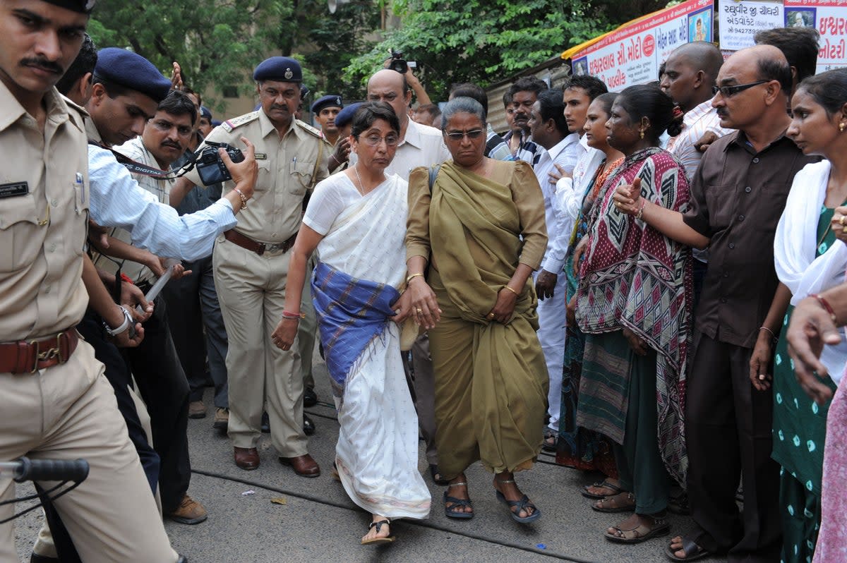 File photo: Former Bhartiya Janta Party MLA and ex-minister in the Narendra Modi state government, Maya Kodnani, is escorted by police on her arrival at a special court in Ahmedabad on 31 August 2012 (AFP via Getty Images)