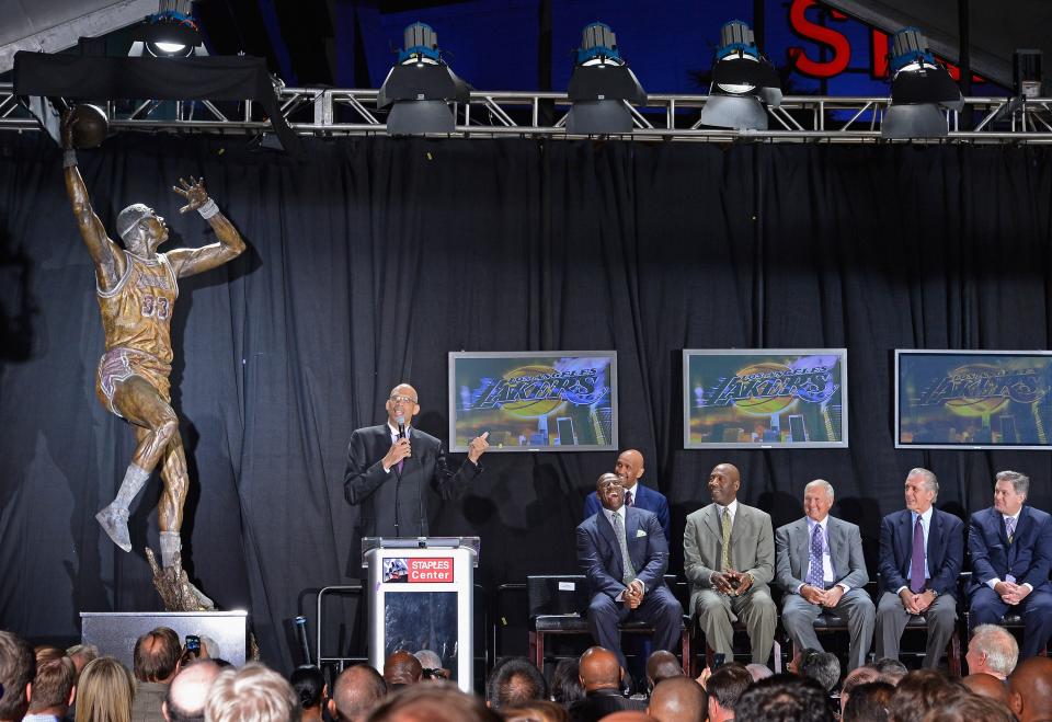 LOS ANGELES, CA - NOVEMBER 16: Los Angeles Lakers legend Kareem Abdul-Jabbar (L) speaks after unveiling a statue of himself at Staples Center before the Lakers take on the Phoenix Suns on November 16, 2012 in Los Angeles, California. Looking on are as his former teammates Earvin "Magic" Johnson (2ndL) James Worthy (3rdL) former Lakers general manager Jerry West, former Lakers coach Pat Riley(2ndR) and AEG president and CEO Tim Leiweke(Photo by Kevork Djansezian/Getty Images)