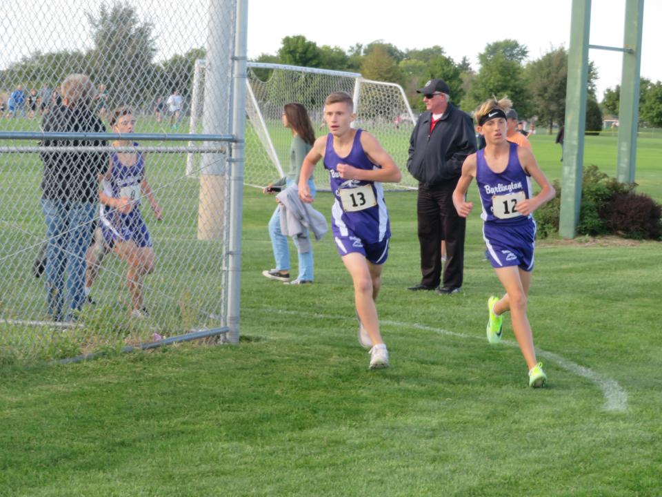 Burlington eighth-grader Cohen Schroeder (right) rounds the turn with teammate Carter Shinn during Thursday's Tony Proctor Invitational at the Burlington Regional RecPlex.