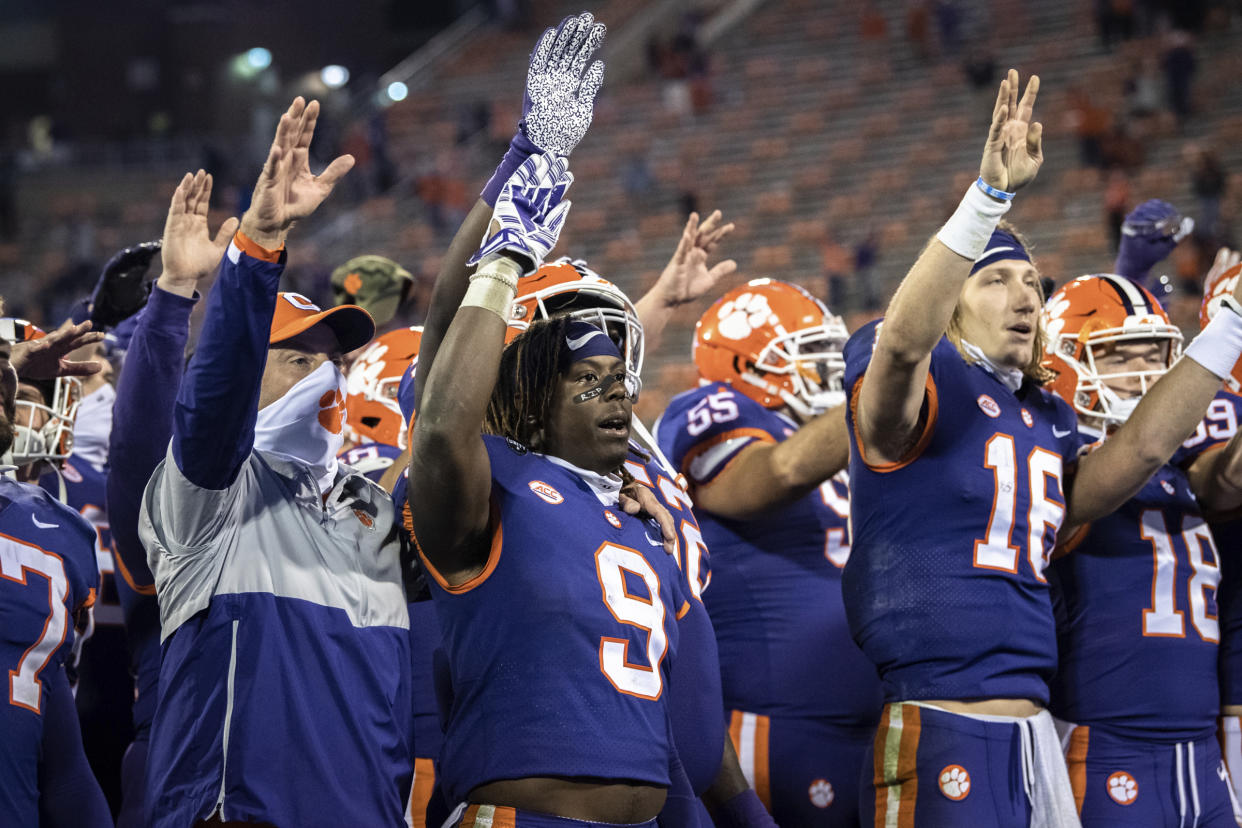 Clemson running back Travis Etienne (9) and quarterback Trevor Lawrence (16) wave after the team's win over Pittsburgh in an NCAA college football game Saturday, Nov 28, 2020, in Clemson, S.C. (Ken Ruinard/The Independent-Mail via AP, Pool)