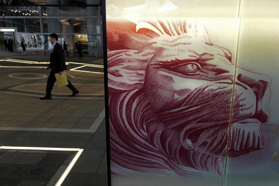 A man walks past the HSBC's Hong Kong headquarters in Hong Kong, Tuesday, Feb. 21, 2017. London-based bank HSBC reported Tuesday that annual profit slumped following a year it said would be remembered for "unexpected economic and political events" and warned of risks in 2017 to the global economy's continuing recovery. (AP Photo/Vincent Yu)