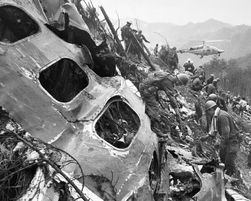 FILE PHOTO: Troops shift through debris of Japan Air Lines Boeing airliner which crashed on a ridge near Mount Osutaka