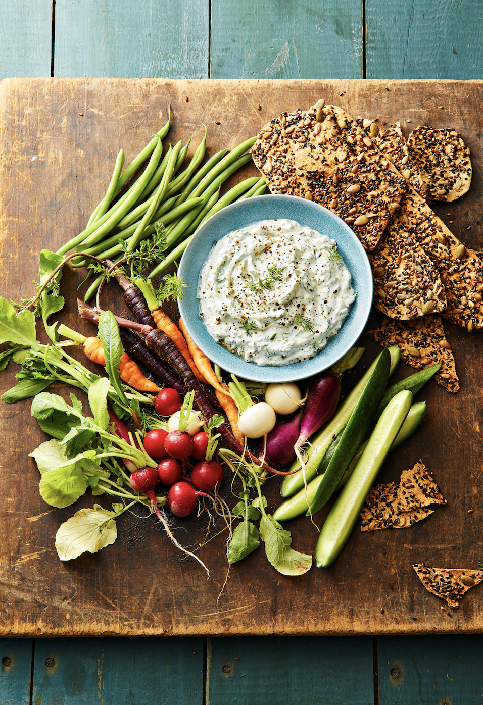 dill dip with fresh vegetables on a cutting board