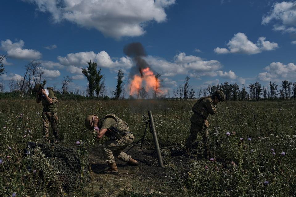 Ukrainian soldiers fire a mortar towards Russian positions at the front line (AP)