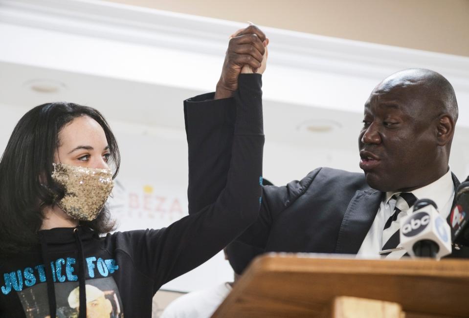 Karissa Hill, left, daughter of Andre Hill, and attorney Ben Crump, right, raise their hands as they speak during a press conference following the indictment of former Columbus police officer Adam Coy on Thursday, Feb. 4, 2021 at the Beze Community Center in Columbus, Ohio. Coy was indicted on four charges in the December 2020 police shooting death of Andre Hill, a Black man. Coy was charged with one count of murder, one count of felonious assault and two counts of dereliction of duty, one of which was for failure to render aid to Hill after he was shot.