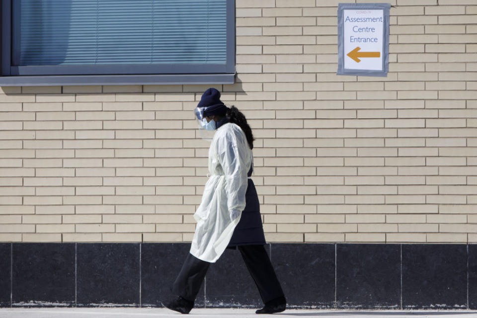 A healthcare worker outside of an assessment centre in Mississauga, Ont. Photographer: Cole Burston/Bloomberg. Image via Getty Images. 