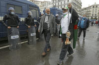 A man holds a bone while shouting "That's what's left for those who vote for the President" as Algerians demonstrate in Algiers to mark the second anniversary of the Hirak movement, Monday Feb. 22, 2021. February 22 marks the second anniversary of Hirak, the popular movement that led to the fall of Algerian President Abdelaziz Bouteflika. (AP Photo/Anis Belghoul)