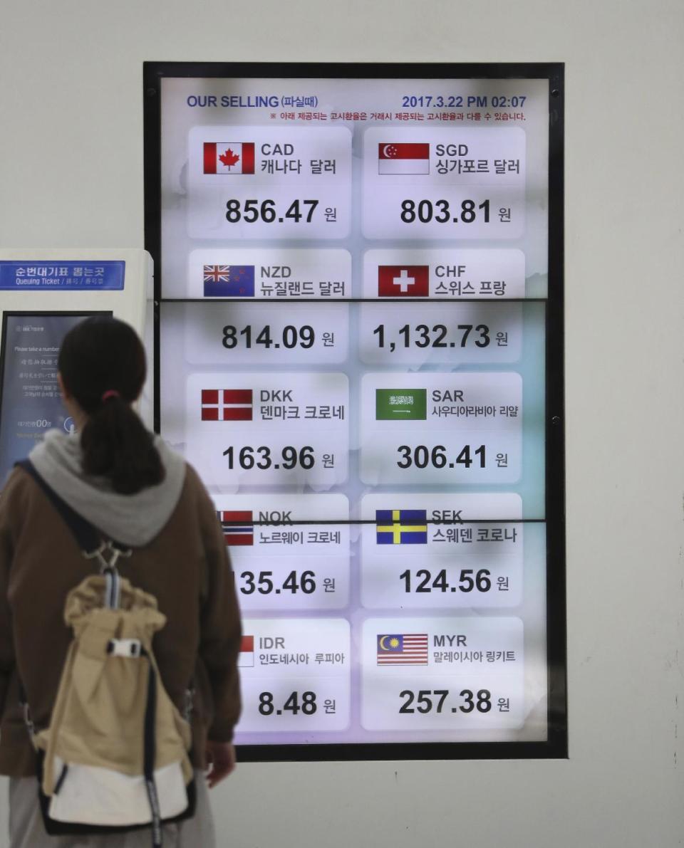 A visitor walks by the screens showing the foreign exchange rates at the train station in Seoul, South Korea, Wednesday, March 22, 2017. Shares fell in Asia early Wednesday after U.S. stocks took their biggest loss in five months. The sell-off overnight on Wall Street was spurred by obstacles to a health care bill backed by President Donald Trump that also raised questions over prospects for his agenda of boosting growth by cutting taxes and regulations. (AP Photo/Lee Jin-man)