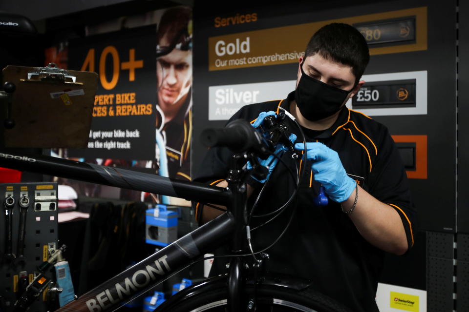 A member of staff works on a bike at Halfords in Rugby, UK