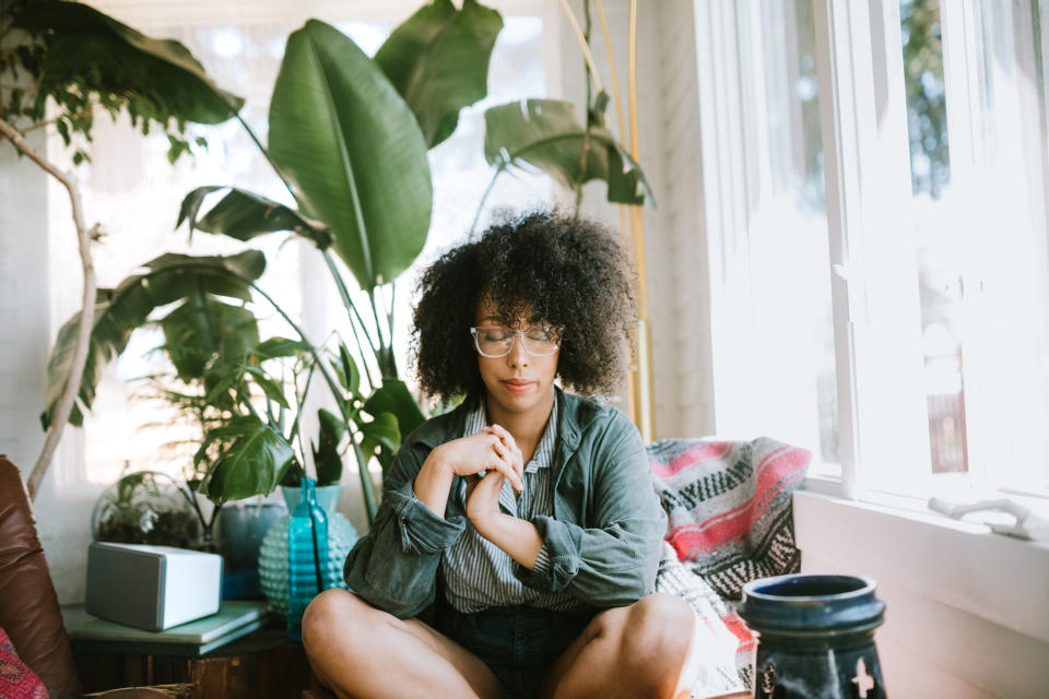 Young Woman Praying or Meditating in Home (Getty Images)