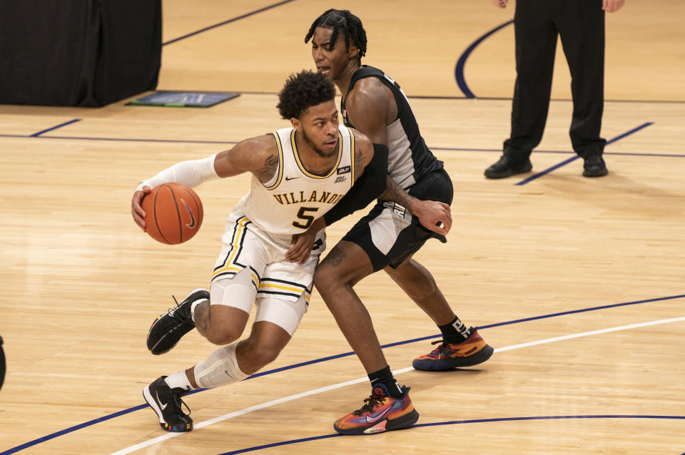 Villanova's Justin Moore, left, makes his move on Providence's David Duke, right, as he drives to the basket during the second half of an NCAA college basketball game Saturday, Jan. 23, 2021, in Villanova, Pa. Villanova won 71-56. (AP Photo/Chris Szagola)