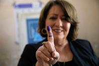 A woman shows her ink-marked finger after casting her vote inside a polling station in the country's parliamentary elections in Basra, Iraq, Sunday, Oct. 10, 2021. Iraq closed its airspace and land border crossings on Sunday as voters headed to the polls to elect a parliament that many hope will deliver much needed reforms after decades of conflict and mismanagement. (AP Photo/Nabil al-Jurani)