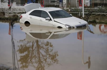 A damaged Mercedes-Benz car is seen at a residential area flooded by the Kinugawa river, caused by typhoon Etau, in Joso, Ibaraki prefecture, Japan, September 11, 2015. REUTERS/Issei Kato