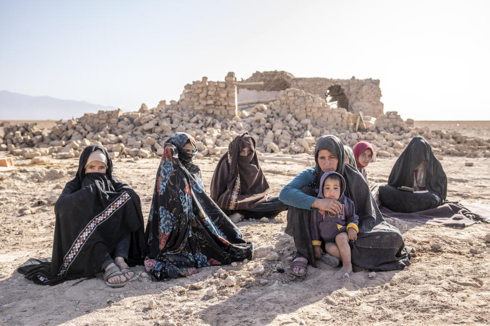 Afghan women sit in front of their houses that were destroyed by the earthquake in Zenda Jan district in Herat province, western of Afghanistan, Wednesday, Oct. 11, 2023. Another strong earthquake shook western Afghanistan on Wednesday morning after an earlier one killed more than 2,000 people and flattened whole villages in Herat province in what was one of the most destructive quakes in the country's recent history. (AP Photo/Ebrahim Noroozi)