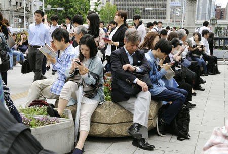 People wait for the resume of operation of train service nearby Yodoyabashi station in Osaka, Osaka prefecture, western Japan, in this photo taken by Kyodo June 18, 2018. Mandatory credit Kyodo/via REUTERS