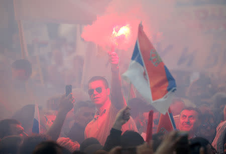 Supporters of Serbian President Aleksandar Vucic burn flare as they wait for his arrival for his campaign rally "The Future of Serbia" in front of the Parliament Building in Belgrade, Serbia, April 19, 2019. REUTERS/Marko Djurica