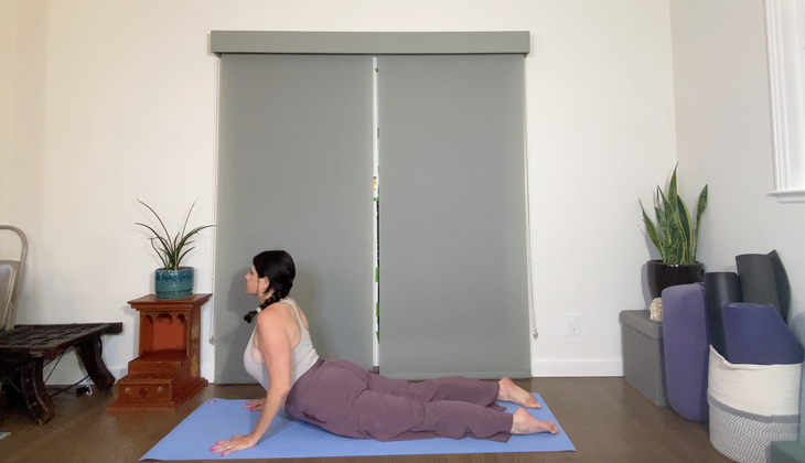 Woman practices a Bhujangasana variation