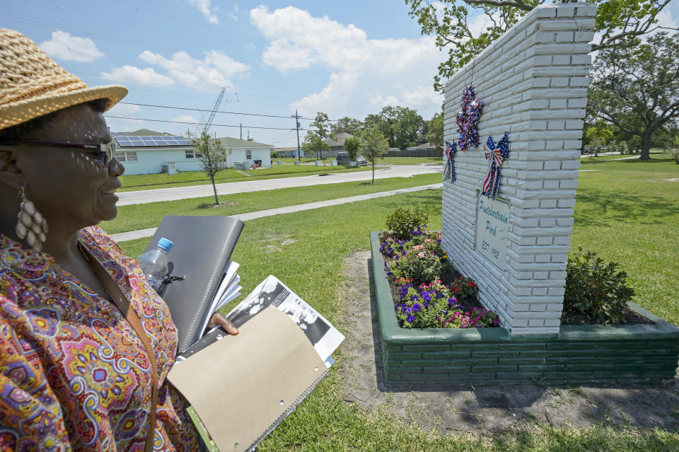 FILE - Carrie Mingo Douglas, a member of the Pontchartrain Park neighborhood association and chair of the association's historic district committee, walks around the historic sign of the housing development that she helps maintain in New Orleans, in a Friday, June 8, 2018 file photo. Pontchartrain Park, the first subdivision built for middle- and upper-class Black residents of New Orleans is now on the National Register of Historic Places. (Max Becherer /The Advocate via AP, File)