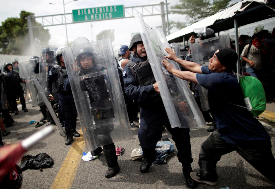 <p>A Honduran migrant, part of a caravan trying to reach the U.S., hits the shield of a federal policeman after storming the Guatemalan checkpoint to enter Mexico, in Ciudad Hidalgo, Mexico, Oct. 19, 2018. (Photo: Ueslei Marcelino/Reuters) </p>