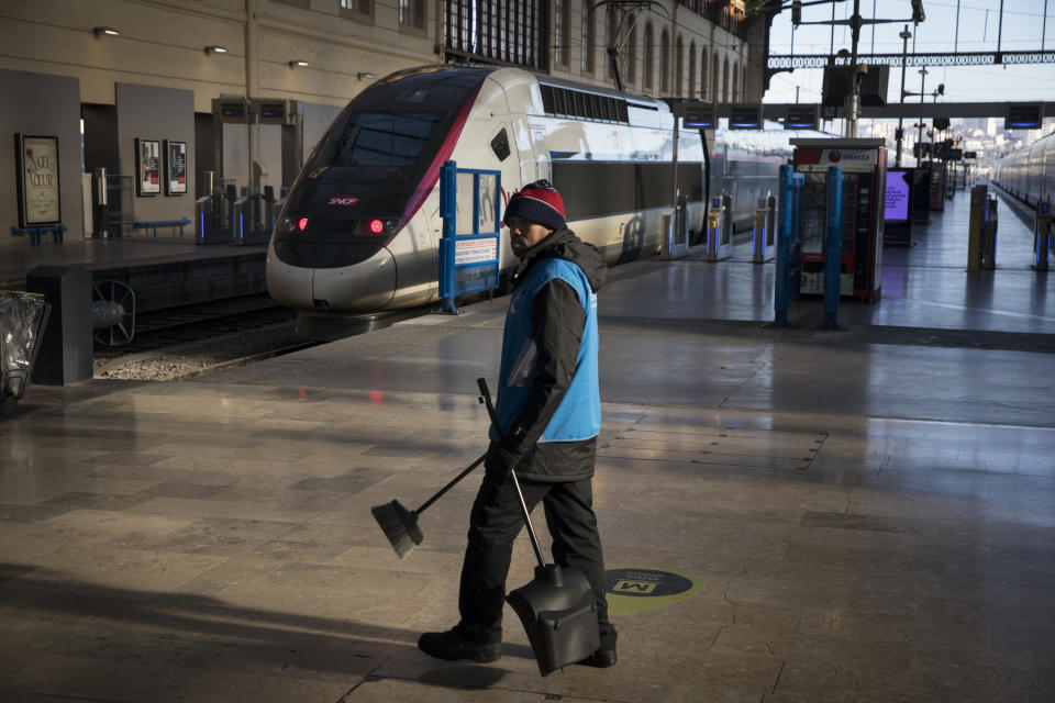 A station employee walks along an empty platform at the Gare St-Charles station, in Marseille, southern France, Sunday, Dec. 8, 2019, on the fourth day of nationwide strikes that disrupted weekend travel around France. (AP Photo/Daniel Cole)
