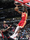 Atlanta Hawks forward Bruno Fernando, right, hangs from the rim after dunking against Chicago Bulls center Andre Drummond during the first half of an NBA basketball game in Chicago, Monday, April 1, 2024. (AP Photo/Nam Y. Huh)
