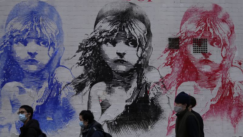 People queue outside a theatre for a performance of “Les Miserables” in London on Tuesday, Dec. 28, 2021.