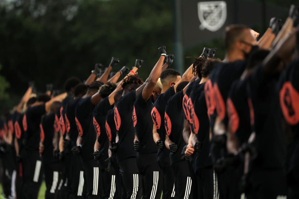 MLS players raise their fists in solidarity with Black Lives Matter before Wednesday's match between Orlando City and Inter Miami in Florida. (Mike Ehrmann/Getty Images)