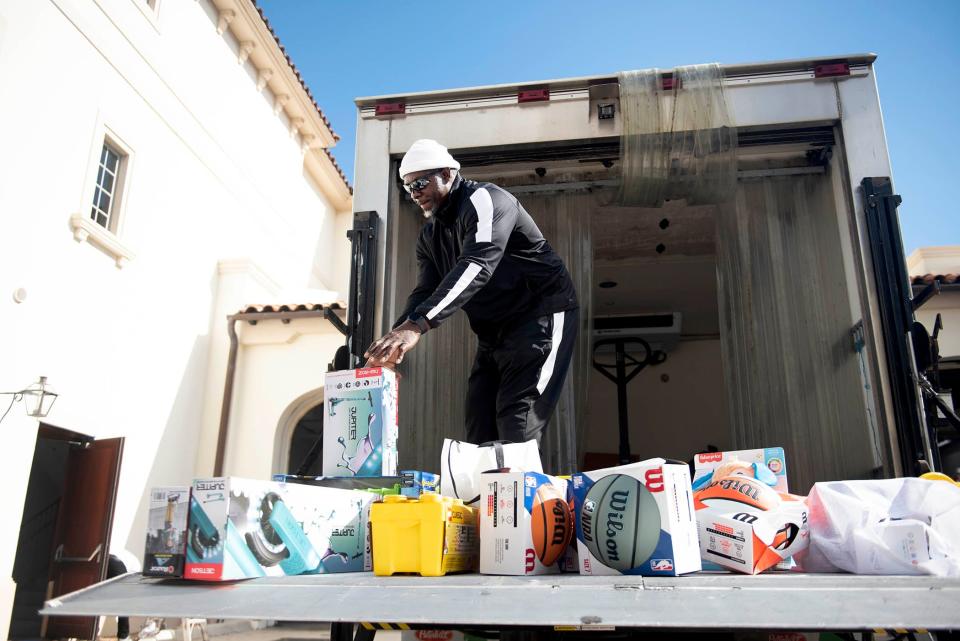 Jerome West of The Glades Initiative loads toys into a truck during the 29th annual Town of Palm Beach United Way Holiday Toy Drive at Palm Beach Fire-Rescue Station No. 1.