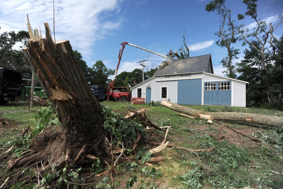 A chainsaw is used to remove the tree that came to rest on the barn of famed bird decoy carver A. Elmer Crowell on the Brooks Academy property in Harwich Center. The tree fell when a tornado touched down in July 2019.