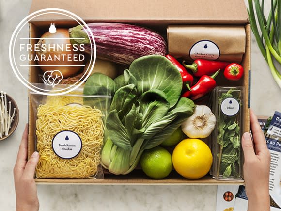 Meal kit box with about 10 different ingredients and Freshness Guaranteed graphic.