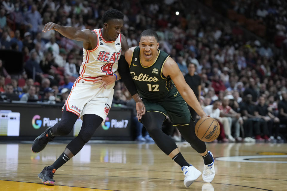 Boston Celtics forward Grant Williams (12) drives to the basket against Miami Heat guard Victor Oladipo (4) during the first half of an NBA basketball game, Tuesday, Jan. 24, 2023, in Miami. (AP Photo/Wilfredo Lee)