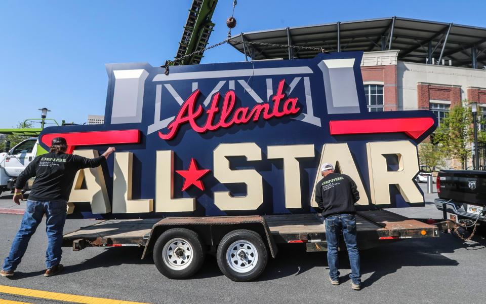 Workers remove an All-Star sign from Truist Park in Atlanta after Major League Baseball moved the showpiece game - AP