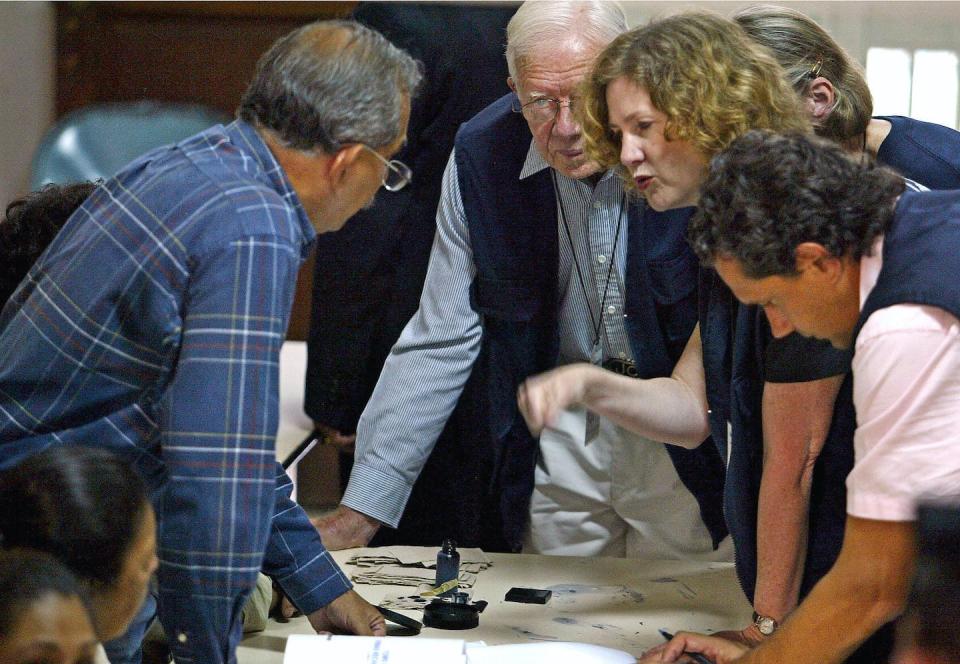 Former President Jimmy Carter and Jennifer Lynn McCoy, to his left, speak with members of the signature’s checking board, May 29, 2004, in Caracas. Carter served as an observer as Venezuelans sought a referendum to recall President Hugo Chavez. <a href="https://www.gettyimages.com/detail/news-photo/former-us-president-jimmy-carter-speaks-with-members-of-the-news-photo/50909679?adppopup=true" rel="nofollow noopener" target="_blank" data-ylk="slk:Juan Barreto/AFP via Getty Images;elm:context_link;itc:0;sec:content-canvas" class="link ">Juan Barreto/AFP via Getty Images</a>