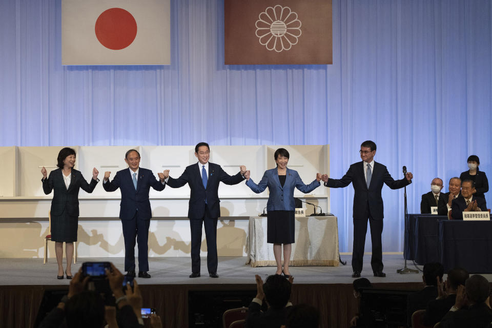 Japanese former Foreign Minister Fumio Kishida, center, celebrates with outgoing Prime Minister Yoshihide Suga, second left, and fellow candidates Seiko Noda, left, Sanae Takaichi, second right, and Taro Kono after winning the Liberal Democrat Party leadership election in Tokyo Wednesday, Sept. 29, 2021. Kishida won the governing party leadership election on Wednesday and is set to become the next prime minister, facing the imminent task of addressing a pandemic-hit economy and ensuring a strong alliance with Washington to counter growing regional security risks. (Carl Court/Pool Photo via AP)