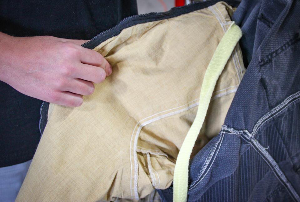 Fall River firefighter Jason Burns shows the different layers inside a turnout coat. The coat contains an outer shell, a moisture barrier, and a thermal barrier.