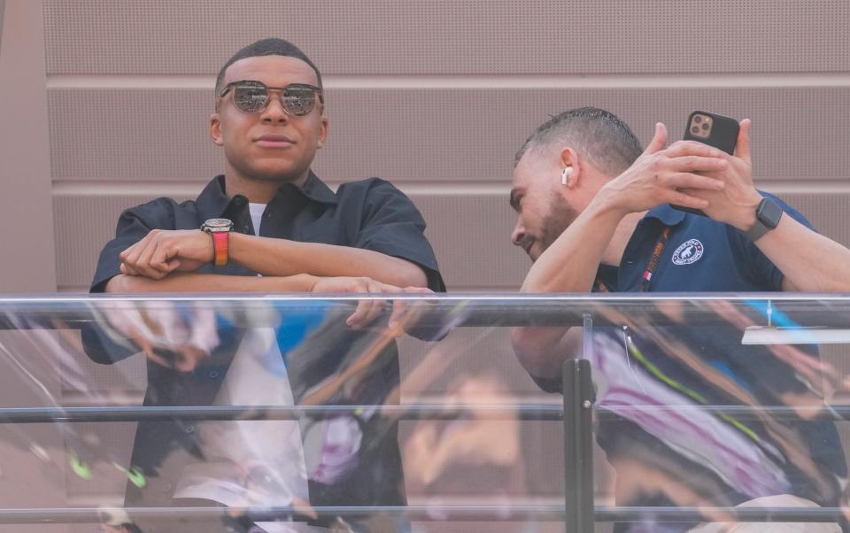 Kylian Mbappe looks over from a terrace in Monaco