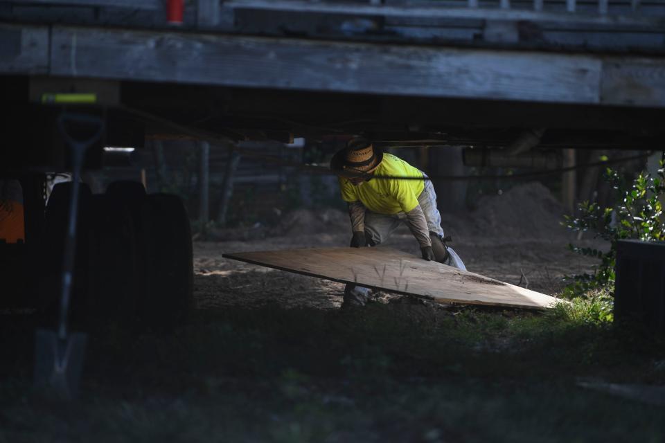 Workers with Fish Brothers House Movers put down wood to help the truck move as it transports the historic Fordyce-Kennedy-Pritchard House from McDowell Street to its new location on East Avenue on Thursday, Sept. 7, 2023.