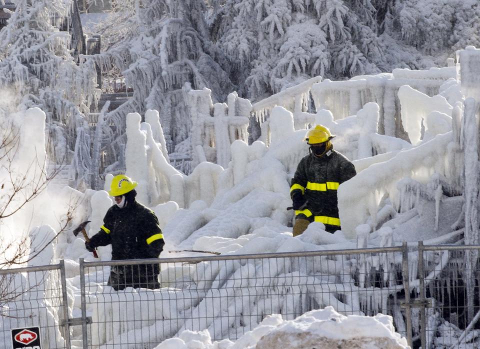 Rescue personnel search through the icy rubble of fire that destroyed a seniors' residence Friday, Jan. 24, 2014, in L'Isle-Verte, Quebec. Five people are confirmed dead and 30 people are still missing, while with cause of Thursday morning's blaze is unclear police said. Authorities are using steam to melt the ice and to preserve any bodies that are buried. (AP Photo/The Canadian Press, Ryan Remiorz)