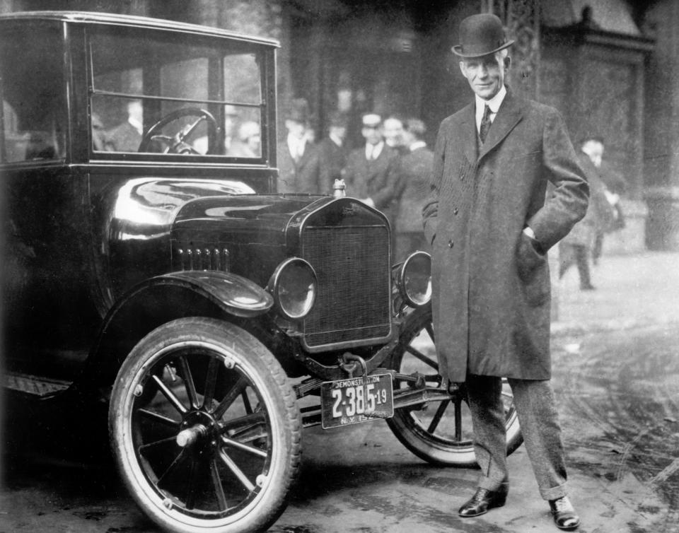 Henry Ford next to a Model T in 1921.