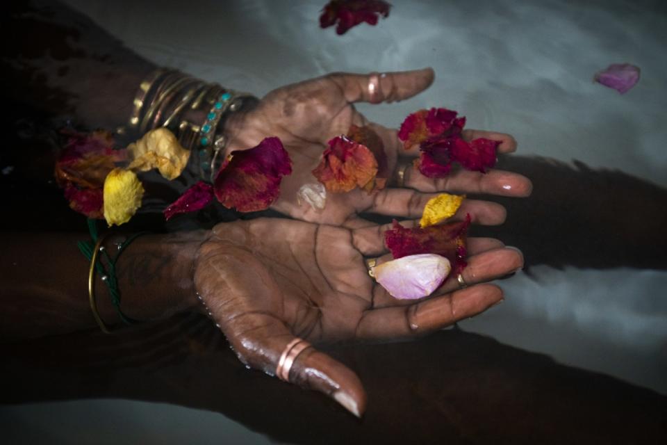 Alua Arthur soaks in the warm water after preparing a bath including candles and rose peddles .