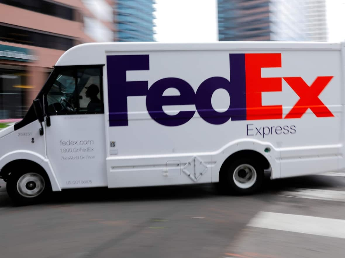 A FedEx truck is driven through downtown in Los Angeles in this file photo. The company expects shipping volumes this holiday season to break records. (Mike Blake/Reuters - image credit)