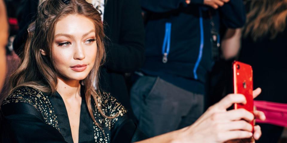 <p>Gigi Hadid snaps a selfie while getting her hair and makeup done backstage. </p>